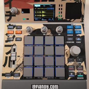 May include: A music production sampler featuring a beige and black graphic faceplate with Japanese characters. The device includes sixteen grey square pads, multiple control knobs, a central digital display screen, and various function buttons.
