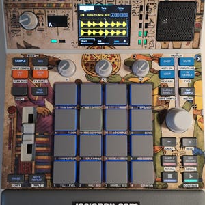 May include: A digital music production device with a colourful design. The device features a screen displaying audio waveforms, numerous buttons, knobs, and pads. The surface is decorated with Egyptian hieroglyphs and Teenage Mutant Ninja Turtles.