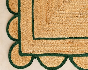 May include: Close-up of a natural jute rug with a scalloped edge. The rug has a woven texture with a dark green border and trim. The text "CARPETEXPORTS" is visible on the rug.