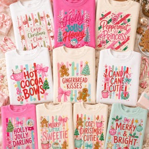 May include: A collection of ten crewneck sweatshirts in white, pink, cream, and light green, each featuring colorful vertical stripes and festive holiday graphics including gingerbread cookies, candy canes, bows, and text like Cozy Christmas Club.