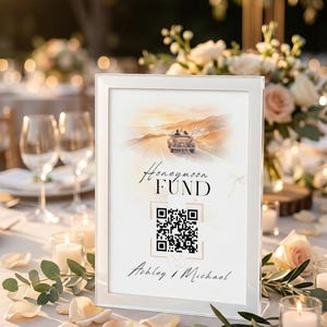 Könnte beinhalten: Ein weiß gerahmtes Schild mit der Aufschrift "Honeymoon Fund" und einem QR-Code. Das Schild zeigt eine Aquarellillustration eines Oldtimers auf einer Straße bei Sonnenuntergang. Namen Ashley & Michael unten.