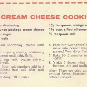 May include: A vintage recipe card for cream cheese cookies. The recipe calls for 1 1/2 cups shortening, 1 3-ounce package cream cheese, 1 1/3 cups sugar, 1 egg yolk, 1 1/2 teaspoons orange extract, 1 1/2 cups sifted all-purpose flour, and 1/2 teaspoon salt. The recipe also includes instructions for baking the cookies.