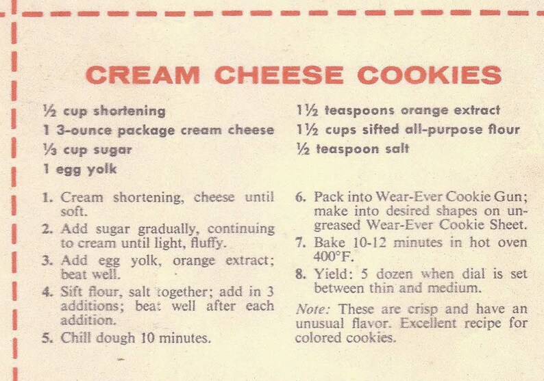 May include: A vintage recipe card for cream cheese cookies. The recipe calls for 1 1/2 cups shortening, 1 3-ounce package cream cheese, 1 1/3 cups sugar, 1 egg yolk, 1 1/2 teaspoons orange extract, 1 1/2 cups sifted all-purpose flour, and 1/2 teaspoon salt. The recipe also includes instructions for baking the cookies.