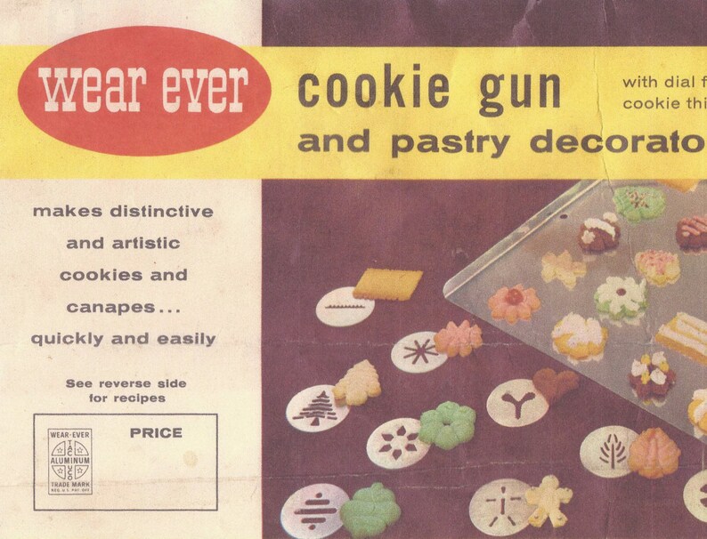 May include: A vintage Wear Ever cookie gun and pastry decorating set with a red and yellow label. The set includes a variety of metal cookie cutters and a dial for adjusting the size of the cookies. The image also shows a baking sheet with cookies and pastry decorations.