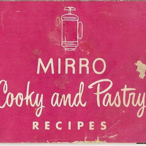 May include: A pink booklet with the title "MIRRO Cooky and Pastry RECIPES" in white text. A white outline of a kitchen appliance is above the title.