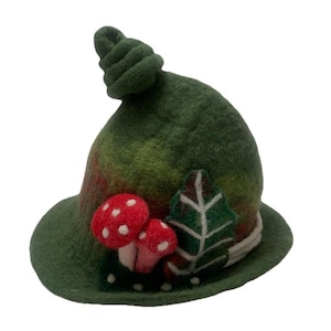 May include: A dark green felted hat with a pointed, spiralled top. The hat features two red mushrooms with white spots and a green leaf appliqué with white stitching on the front. The brim is slightly curved, and the texture is soft and fuzzy.