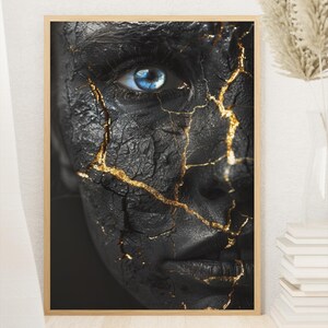 May include: A framed art print featuring a close-up of a face with black textured skin and striking blue eyes. The black surface is intricately detailed with golden cracks, creating a unique and artistic aesthetic. The artwork is displayed in a wooden frame.