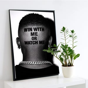 Puede incluir: Impresión artística enmarcada en blanco y negro que muestra la parte posterior de la cabeza de una persona con el texto "WIN WITH ME OR WATCH ME". Se ve un collar de cadena plateada.