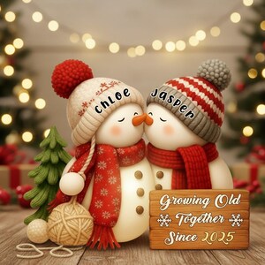 May include: A pair of snowman figurines, each wearing a hat and scarf, kissing. One snowman has a red pom-pom hat and the other a striped hat. A wooden sign reads "Growing Old Together Since 2025".