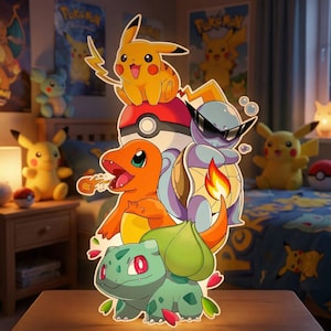 Puede incluir: Un recorte colorido de estilo caricatura con varios personajes de Pokémon, incluyendo a Pikachu, Charmander, Squirtle y Bulbasaur. Los personajes están apilados uno encima del otro, con una Pokéball en el centro. El fondo incluye carteles y peluches temáticos de Pokémon.