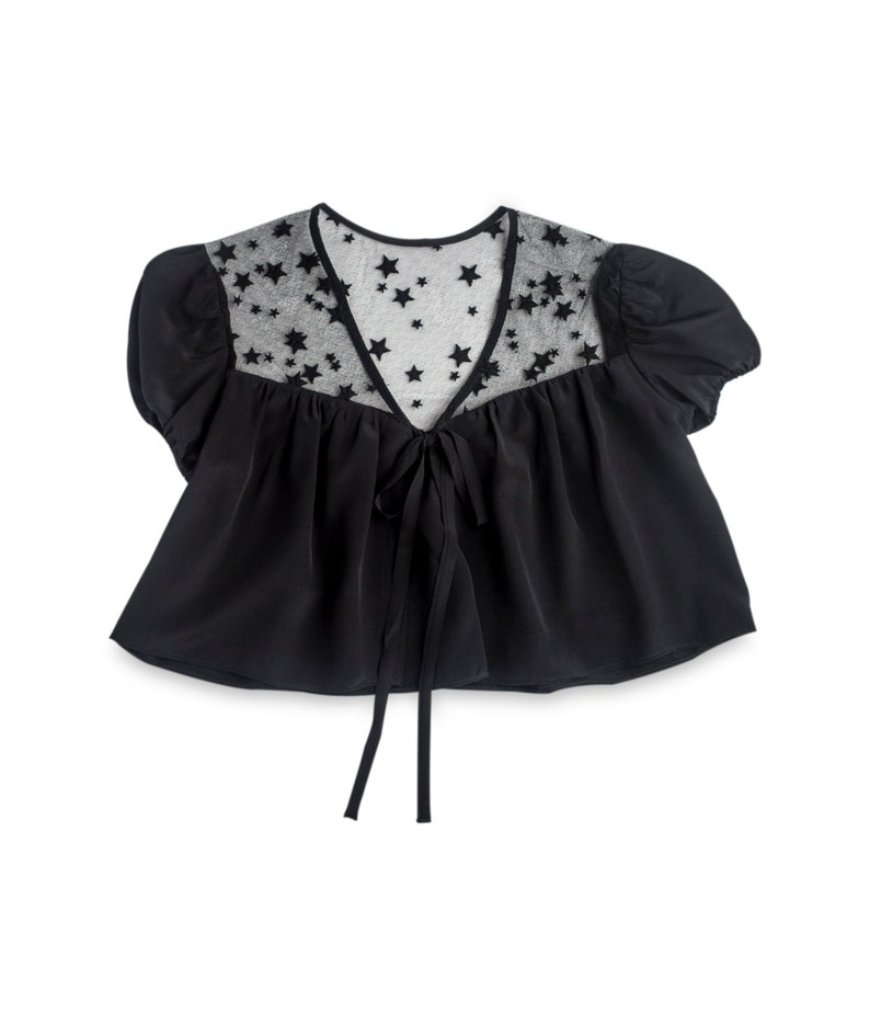 May include: A black cropped top with a sheer star-shaped overlay and a tie at the front.