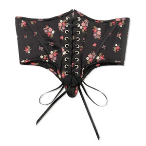 Back flat view of Swiss waist cincher underbust corset with multi floral print on a black background and shirred bodice front panel with sheer rainbow flower detailing in nostalgic cottagecore Victorian style, perfect for romantic pinups.