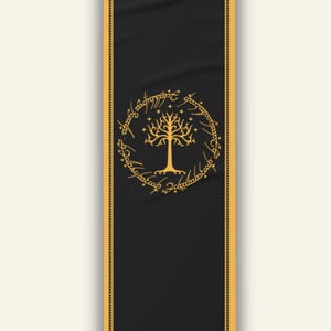 May include: Black bookmark with a gold border and a gold tree design in the center. The tree is surrounded by a gold circular inscription. The bookmark has a vertical orientation.