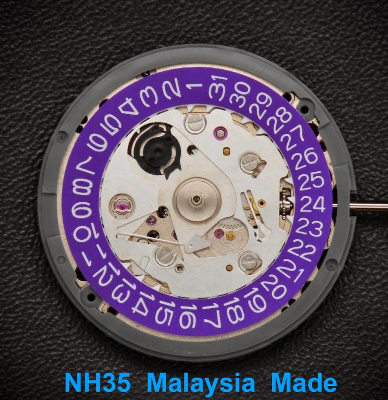 Puede incluir: Primer plano de un movimiento de reloj con una rueda de fecha p&uacute;rpura y engranajes plateados. La rueda de fecha muestra n&uacute;meros del 1 al 31. El texto "NH35 Malaysia Made" est&aacute; en la parte inferior.