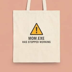 Könnte beinhalten: Cremefarbene Tragetasche mit einem schwarz-gelben Warnschild-Grafik und dem Text "MOM.EXE HAS STOPPED WORKING". Die Tasche hat zwei Griffe und ist aus einem robusten Stoff gefertigt.