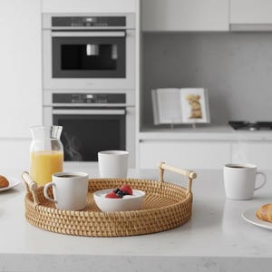 Puede incluir: Una escena de desayuno con cruasanes, café y zumo. Una bandeja tejida contiene un cuenco de bayas y dos tazas. Platos adicionales con pasteles y cuencos con bayas están en la encimera. Cocina moderna con electrodomésticos.