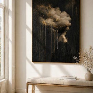May include: A framed art print depicting a woman with a cloud-like form above her head. The artwork is mainly black with gold highlights, producing a dramatic and ethereal effect. The woman is shown in profile, wearing a dark dress.