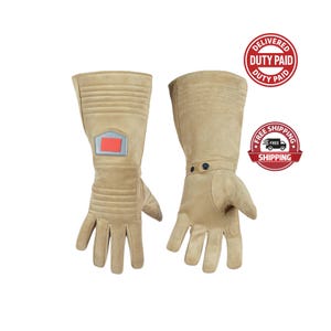 May include: A pair of tan gloves with a long cuff design. The gloves have a rectangular patch with red and blue accents on the left glove. The gloves are made of a suede-like material and have ribbed detailing.