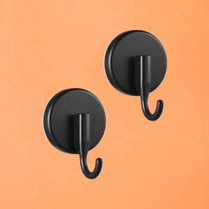 May include: Two black metal wall hooks with a circular base and a curved hook. The hooks are mounted on an orange background. The hooks are designed for hanging items.
