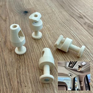 Può includere: Quattro clip di finitura interna per auto in plastica bianco sporco. Ogni clip ha una base cilindrica, uno stelo e una parte superiore con un foro o una fessura. Le clip sono disposte su una superficie di legno. Una piccola immagine mostra una clip installata in un'auto.