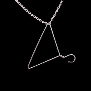 May include: A silver necklace with a triangle pendant that resembles a wire coat hanger.