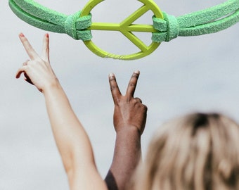 Pulsera moderna con signo de la paz de gamuza sintética y dije de metal esmaltado