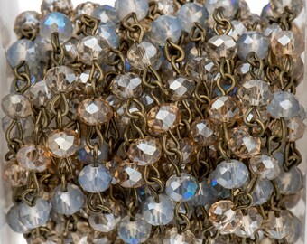 May include: A spool of crystal bead chain with alternating light blue and brown beads. The chain is made of metal and is perfect for jewelry making.