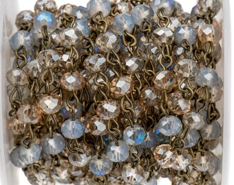 May include: A spool of crystal bead chain with alternating light blue and brown faceted beads. The chain is made of metal and is perfect for jewelry making.