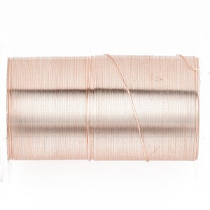 May include: A close-up of a spool of copper wire. The wire is wound tightly around the spool, and the ends of the wire are visible.