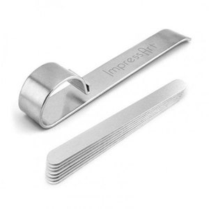 May include: A set of silver metal jewelry making tools. One tool has a curved handle and the text "ImpressArt". A stack of thin, rectangular metal blanks is also included. The tools are on a white background.
