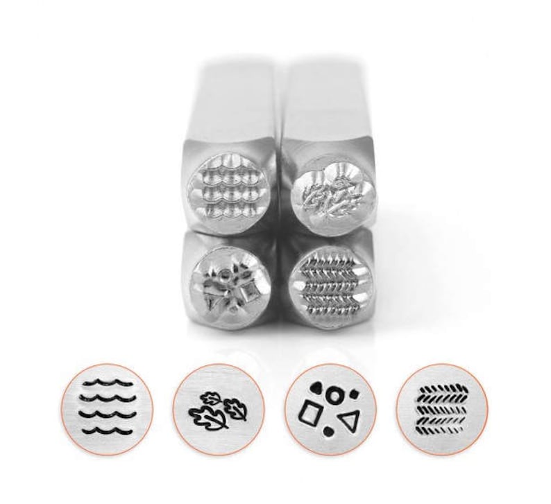 May include: A set of four metal stamps with various textured designs, including waves, leaves, geometric shapes, and a woven pattern. The stamps are displayed with their corresponding impressions, showcasing the detailed patterns. The stamps are made of silver metal.
