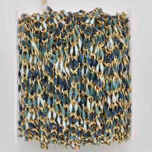 May include: A spool of gold chain with blue, teal, and white enamel accents. The chain is coiled and ready to be used for jewelry making.