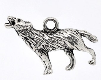 May include: A silver-colored pendant in the shape of a howling wolf. The wolf is depicted with its mouth open, head raised, and a textured surface. The pendant has a small loop at the top for attaching to a chain or cord.