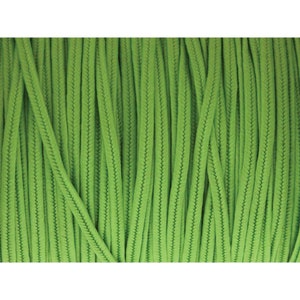 May include: Close-up of a spool of bright green cord. The cord is tightly woven with a textured surface, creating a ribbed effect. The vibrant green color dominates the image, suggesting a craft or DIY project.