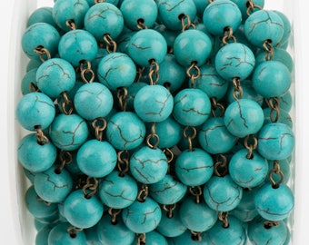 May include: A spool of turquoise-colored round beads with a cracked, veined pattern. The beads are strung together with small, antique brass-colored chain links. The beads are a bright, solid color, and the chain is tightly wound.