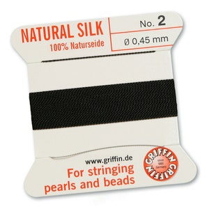 May include: A spool of black natural silk thread for stringing pearls and beads. The spool is labeled "Natural Silk 100% Naturseide" and "No. 2 Ø 0,45 mm".