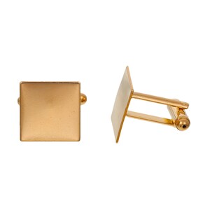 May include: Two gold-colored square cufflinks. One cufflink is shown face-on, displaying a smooth, reflective surface. The other cufflink is shown at an angle, revealing the post and swivel mechanism. The cufflinks are set against a white background.