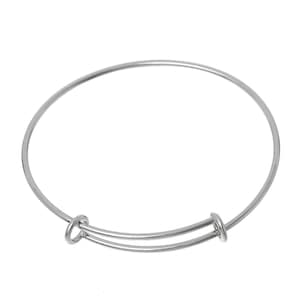May include: A silver-colored adjustable bangle bracelet. The bracelet features a simple, circular design with a sliding mechanism for size adjustment. The metal has a shiny finish, reflecting light. This jewelry item is suitable for various wrist sizes.