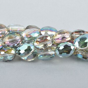 Pode incluir: Um fio de contas de vidro ovaladas iridescentes. As contas t&ecirc;m um design facetado e s&atilde;o enfiadas em um fio transparente.