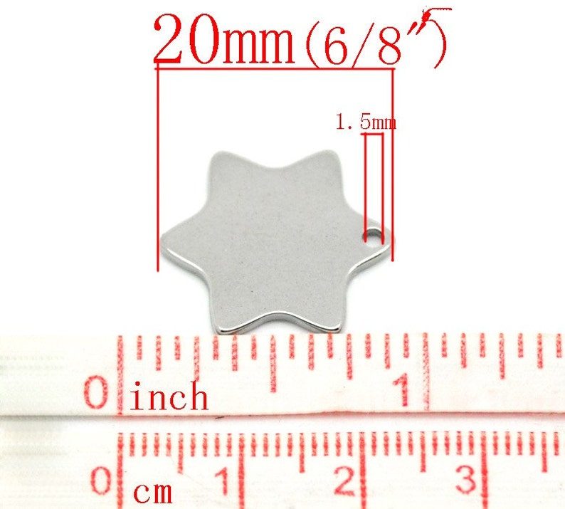 May include: A silver-colored, six-pointed star charm with a small hole for stringing. The charm measures 20mm (6/8") in diameter and 1.5mm thick. A ruler with inch and centimeter markings is shown below the charm.