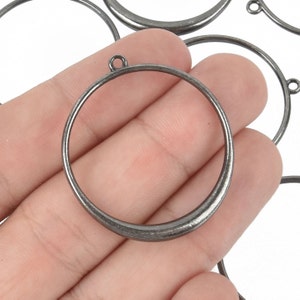 May include: A set of silver-toned metal rings with a loop at the top. The rings are smooth and have a slightly rounded edge.