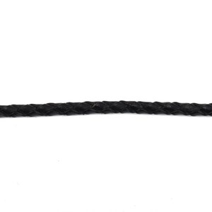 May include: A close-up of a black braided leather cord.