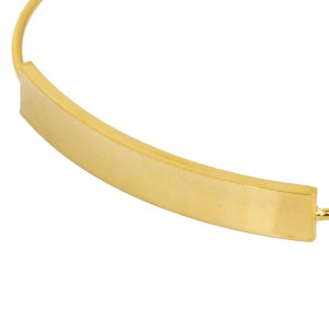 May include: A gold-colored necklace with a curved bar pendant. The pendant is rectangular and has a brushed finish. The necklace is on a white background.
