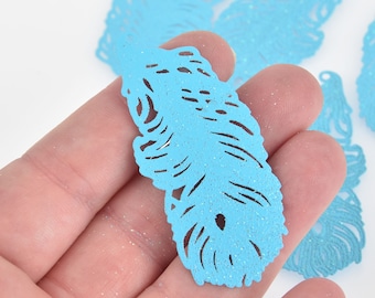 May include: Light blue glitter feather-shaped cutouts. The cutouts have intricate feather vein details and a small hole at the top for stringing. These craft supplies are ideal for scrapbooking, card making, or other DIY projects.