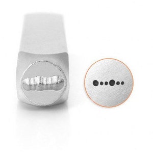 May include: A silver metal stamp with a rounded head and a rectangular handle. The stamp's head features a design of a series of connected dots. A circular impression of the design is shown next to the stamp.