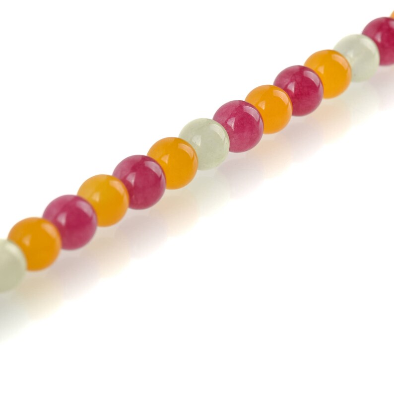 Puede incluir: Un collar de cuentas de piedras preciosas de colores. Las cuentas son redondas y vienen en tonos de amarillo, rojo y blanco roto. Las cuentas est&aacute;n ensartadas, creando un collar o pulsera.