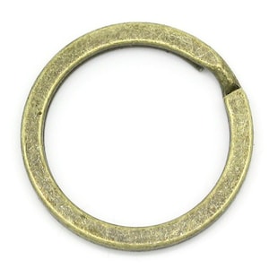 May include: A single antique gold-toned metal key ring. The ring is smooth and has a slightly rounded edge.