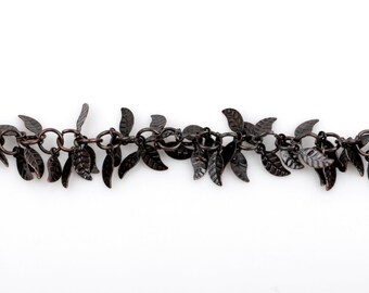 May include: A chain necklace with small, dark brown metal leaves hanging from it. The leaves are arranged in a cascading pattern, creating a delicate and feminine look.