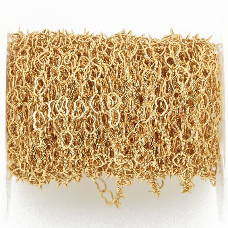 Pu&ograve; includere: Un rotolo di catena dorata con maglie a forma di cuore. La catena &egrave; avvolta strettamente, mostrando l'intricato design e la qualit&agrave; riflettente del metallo. Adatta per la creazione di gioielli e altri progetti creativi.