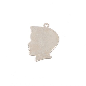May include: Silver charm shaped like a person's profile. The charm is a simple silhouette with no details.